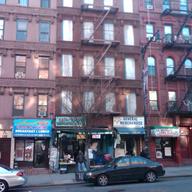 buildings on East 116th Street between Lexingon and Park where the first floor is rented commerically but the several former residential apartment floors are boarded up.